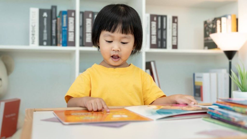 budak kecil membaca buku sambil bercerita